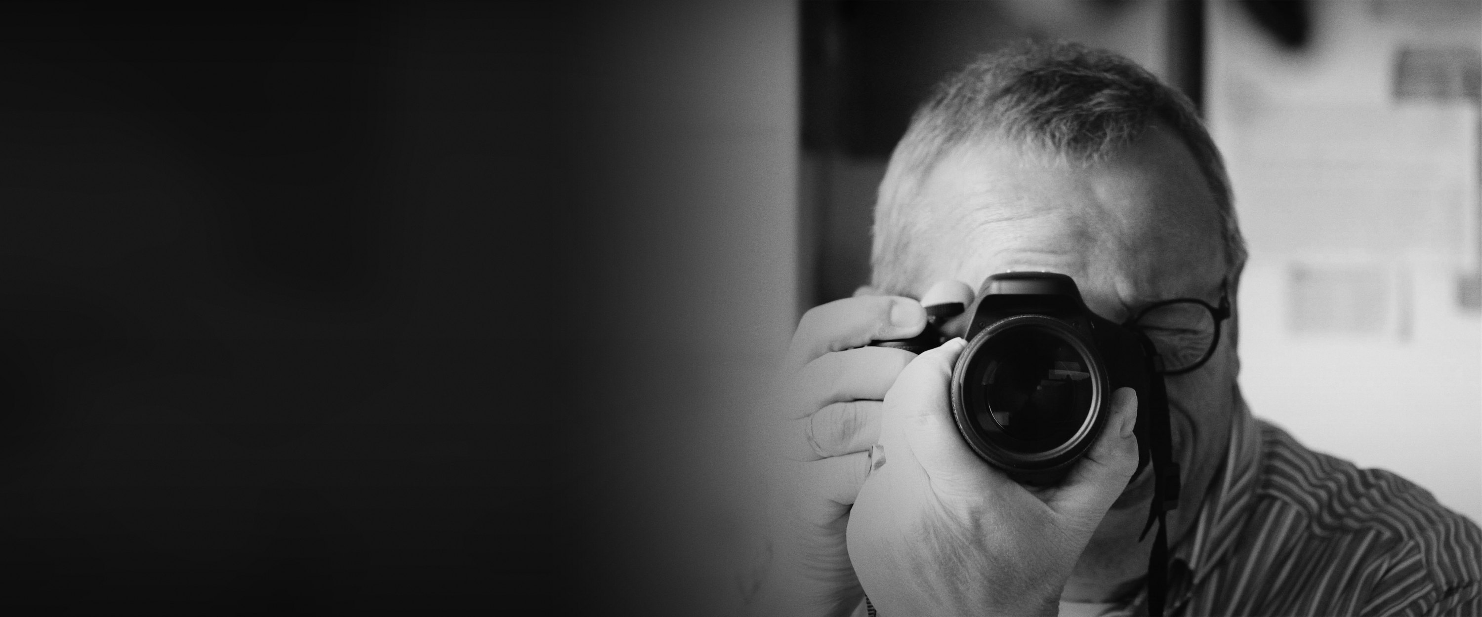 Jan Gorter in zwart-wit, met de camera voor zijn oog